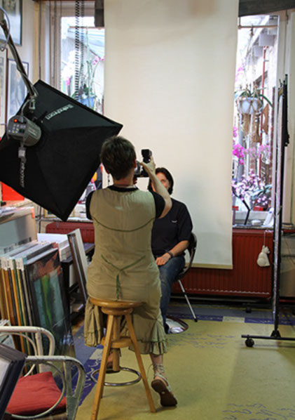 Photographe en studio ajustant son appareil avant un portrait